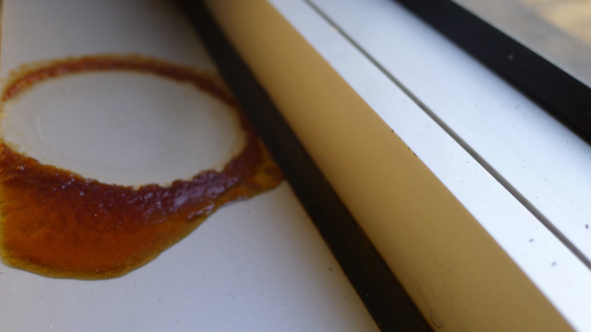 A coffee stain on a dirty window ledge