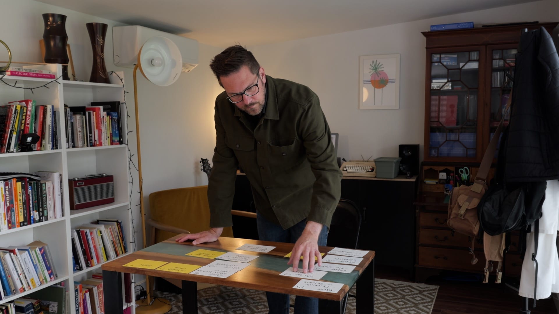 A photo of Rob Lambert stood over a desk moving index cards around