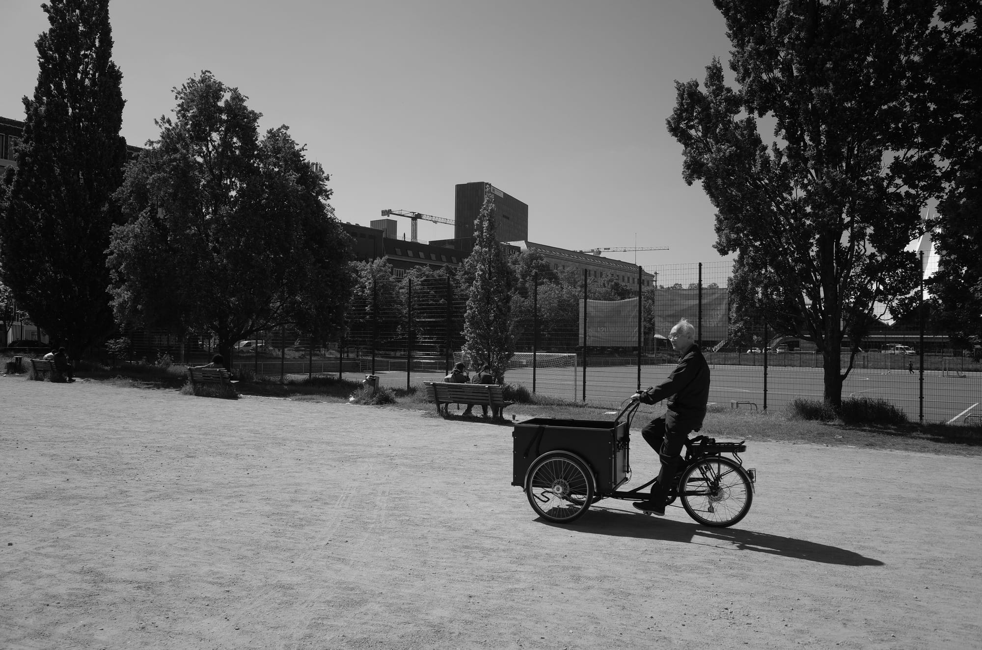 A photo of a man on a bike in Berlin. Cool bike.