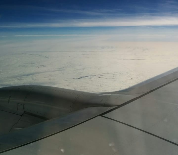 A photo taken out of an airplane window with fluffy clouds