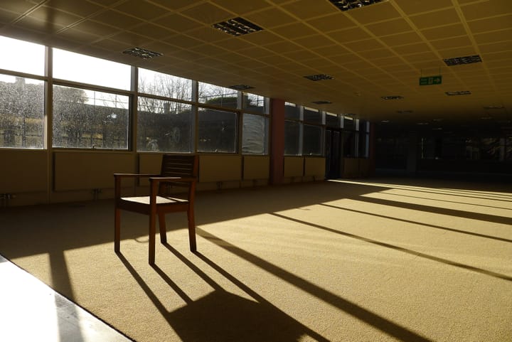 A photo of a lone chair in an empty office space