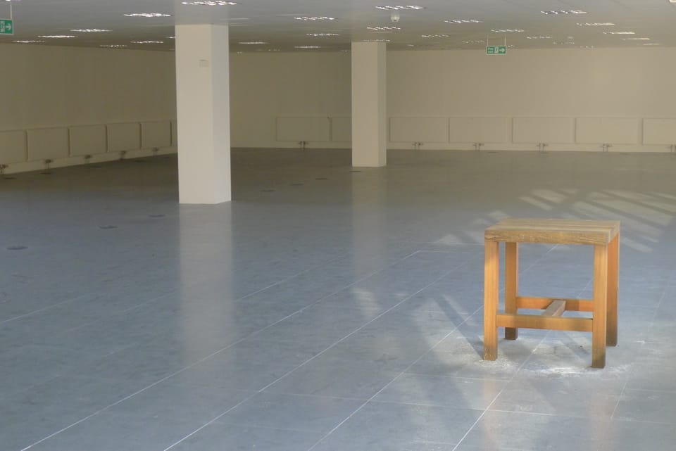 A photo of a stool in an abandoned office space