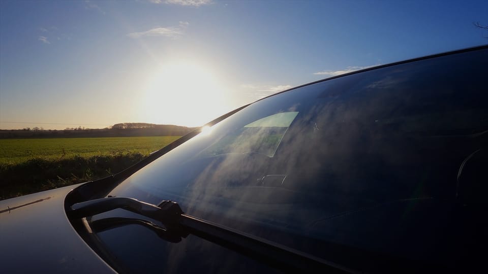 A photo of some field over looking the front car window