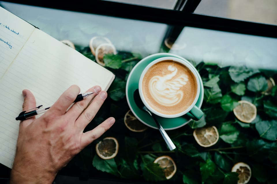 A photo of a notebook and coffee on a table