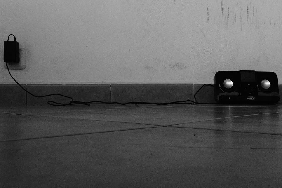 A photo of a speaker against a wall in black and white